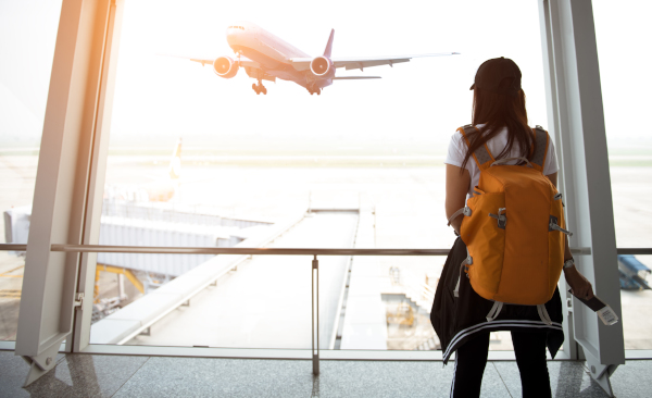 Etudiant regardant l'envol d'un avion - Partez sans stress avec l'assurance santé à l'étranger de la SMENO