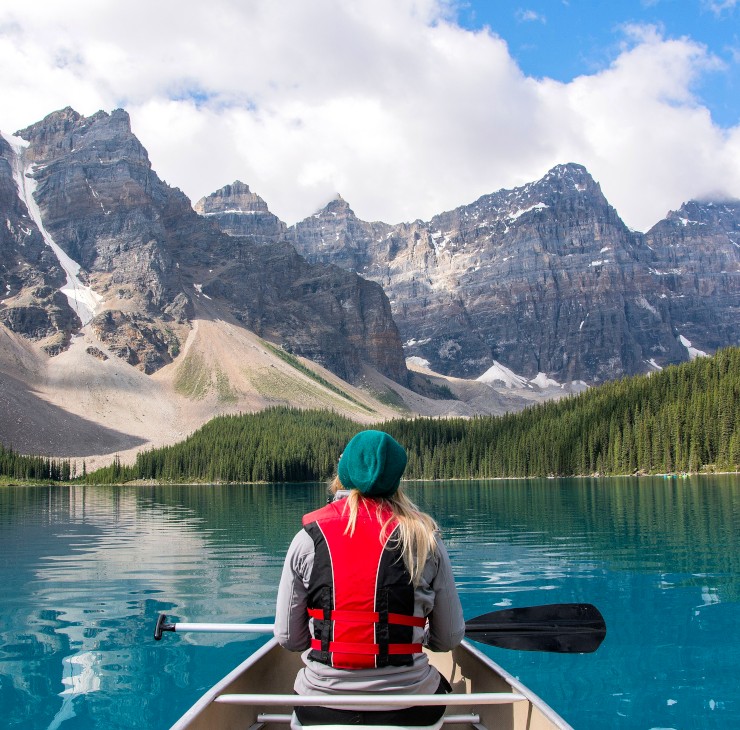 Femme sur une barque explorant un paysage canadien - Découvrez le Canada, destination parfaite pour ses études !