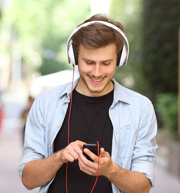 Jeune écoutant de la musique à pied