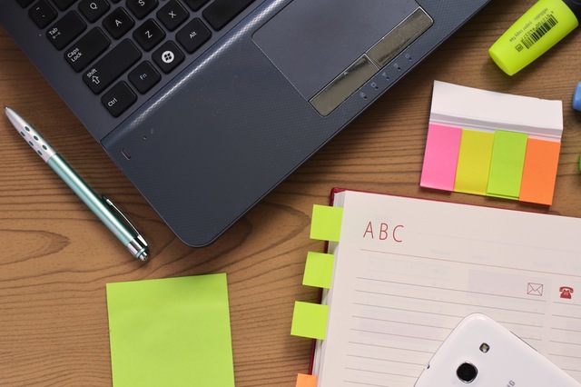 Ordinateur couvert de post-it pour planifier votre voyage à l'étranger - la SMENO vous livre ses astuces pour partir serein